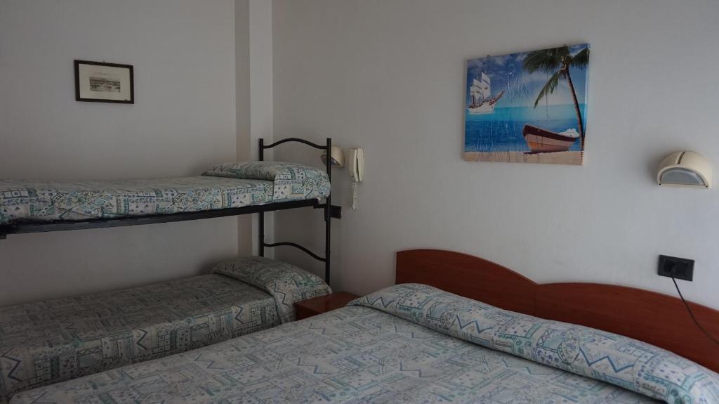 une chambre avec deux lits superposés et un tableau au mur dans l'établissement Hotel Daria, à Rimini