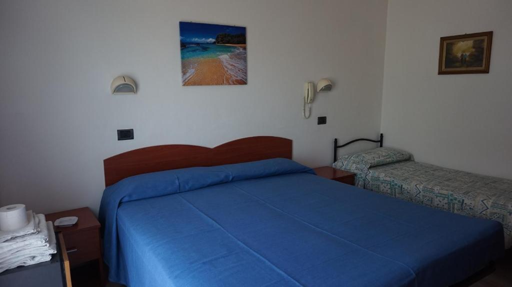 une chambre avec un lit avec un couvre-lit bleu dans l'établissement Hotel Daria, à Rimini
