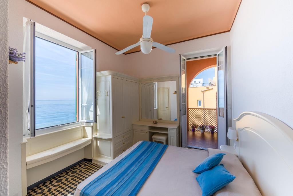 une chambre avec un lit et une grande fenêtre dans l'établissement Miramare di Varigotti, à Varigotti