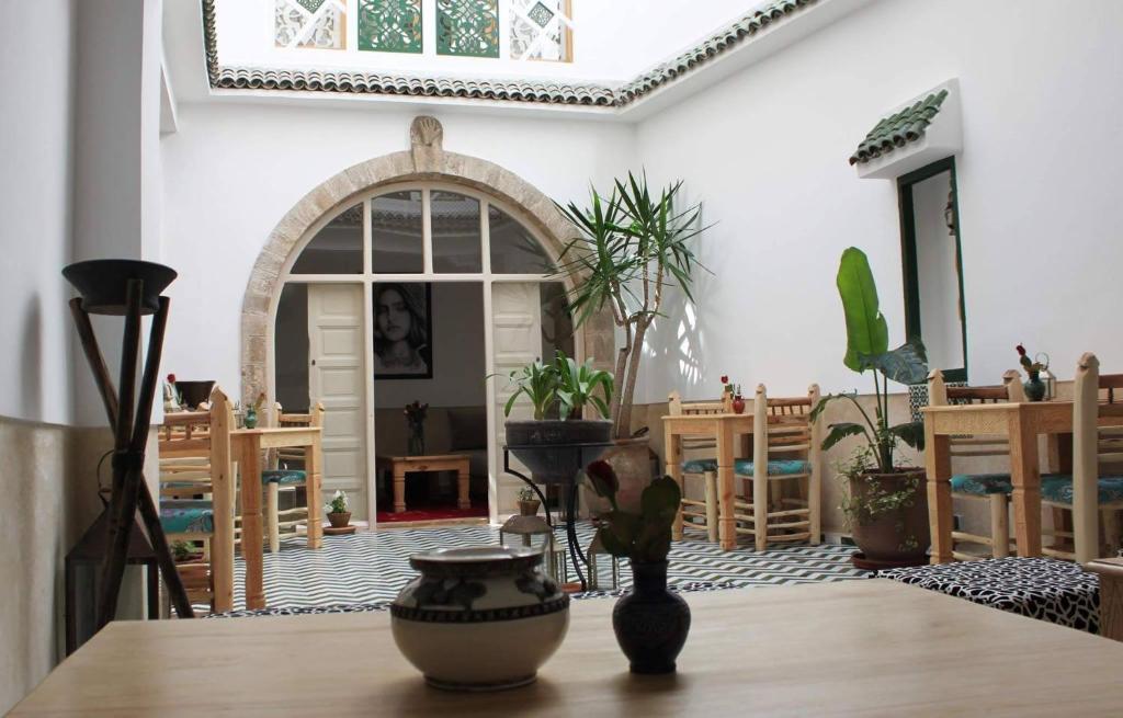 une chambre avec une table avec des plantes en pot dans l'établissement Jennat El Mossafir-Riad privé avec services, à Essaouira