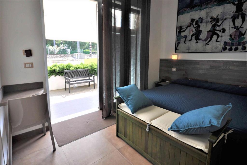 - une chambre avec un lit et une vue sur une terrasse dans l'établissement Hotel Miramare Dipendenza, à Pineto