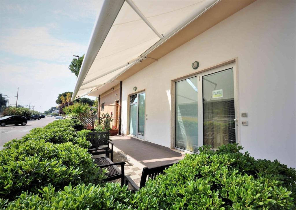 un groupe de bancs assis à l'extérieur d'un bâtiment dans l'établissement Hotel Miramare Dipendenza, à Pineto