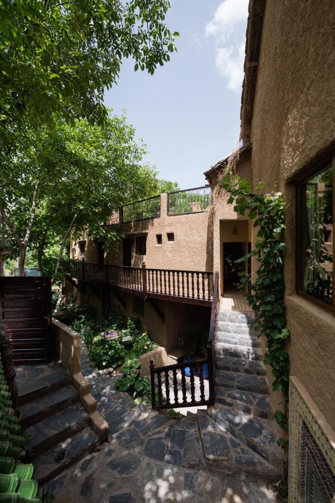 un bâtiment avec des escaliers et un banc dans une cour dans l'établissement Riad Oussagou, à Imlil