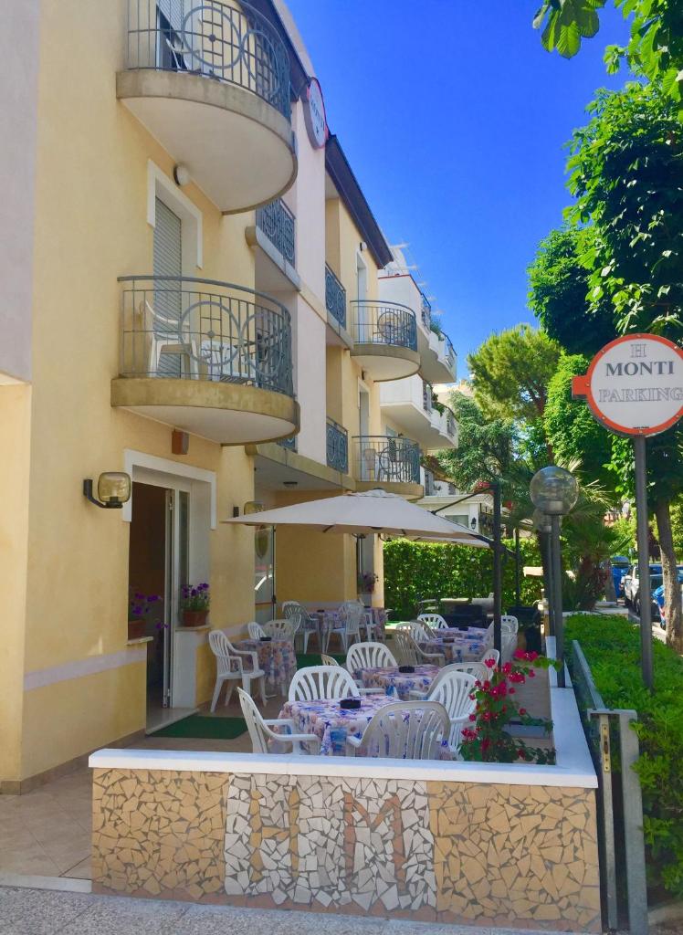 un restaurant avec des chaises et des tables devant un bâtiment dans l'établissement Hotel Monti, à Riccione