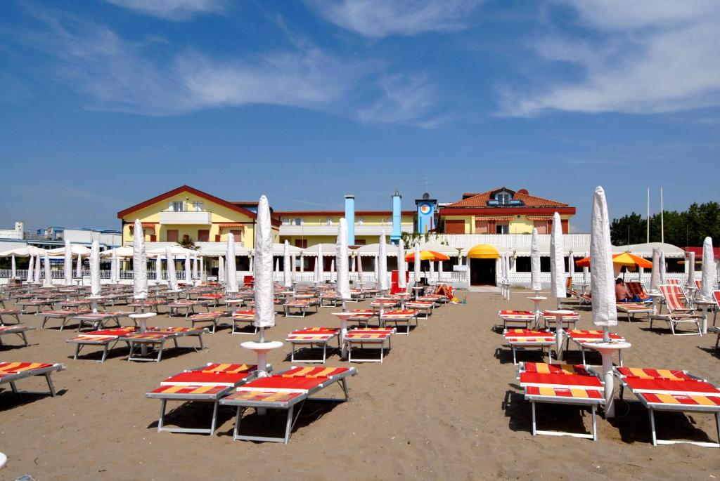un groupe de tables et de chaises sur une plage dans l'établissement Hotel Righetto Fronte Mare, à Cavallino-Treporti 34 autres photos