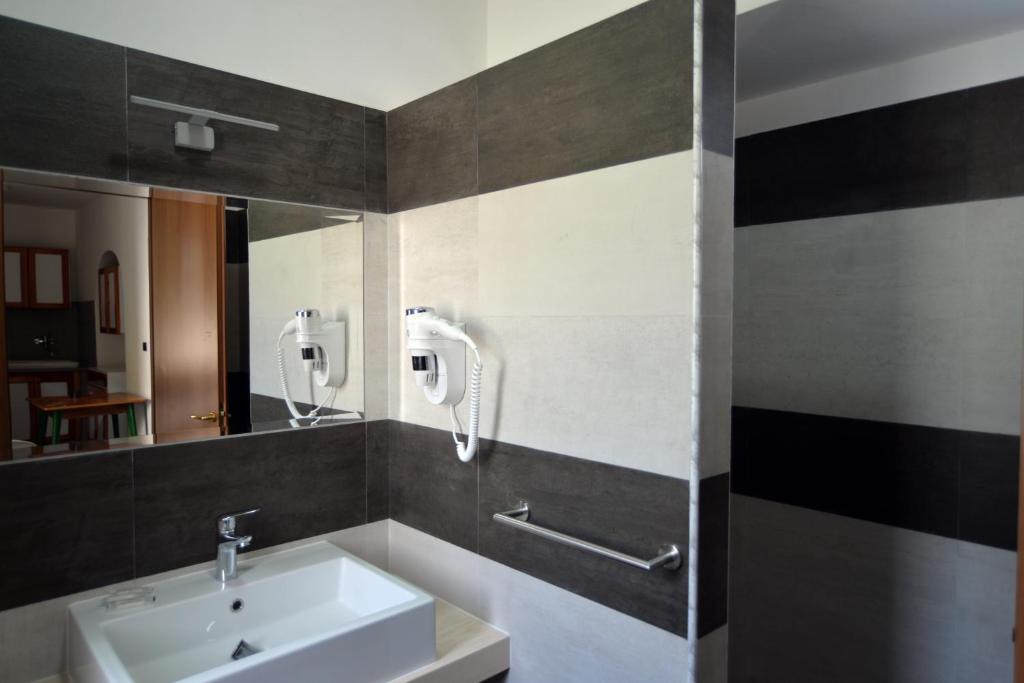 une salle de bain avec un lavabo et un miroir dans l'établissement Residence M3, à Peschici