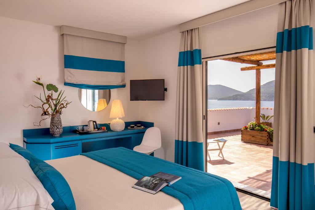 une chambre d'hôtel avec un lit et une vue sur l'océan dans l'établissement El Faro Hotel & Spa, à Porto Conte