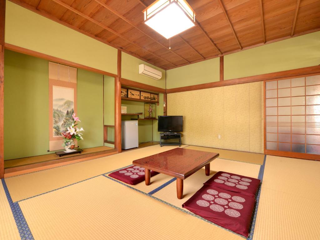 - un salon avec une table et des tapis rouges dans l'établissement Kikuya Ryokan, à Tonosho 22 autres photos