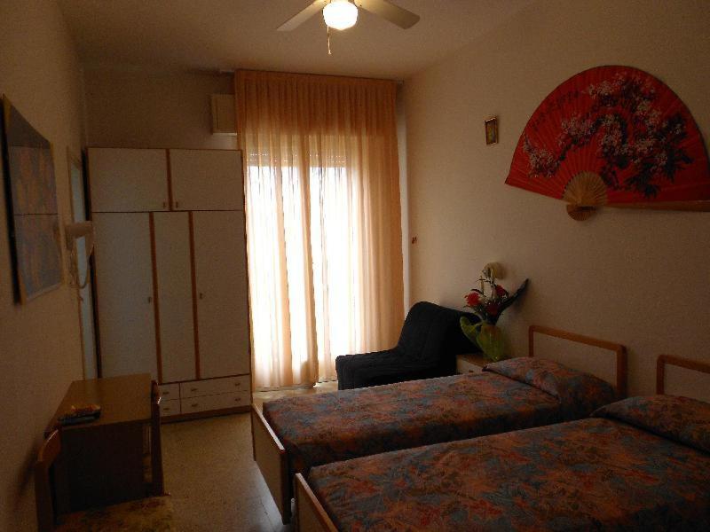 - un salon avec deux lits et une fenêtre dans l'établissement Hotel Vevey, à Rimini