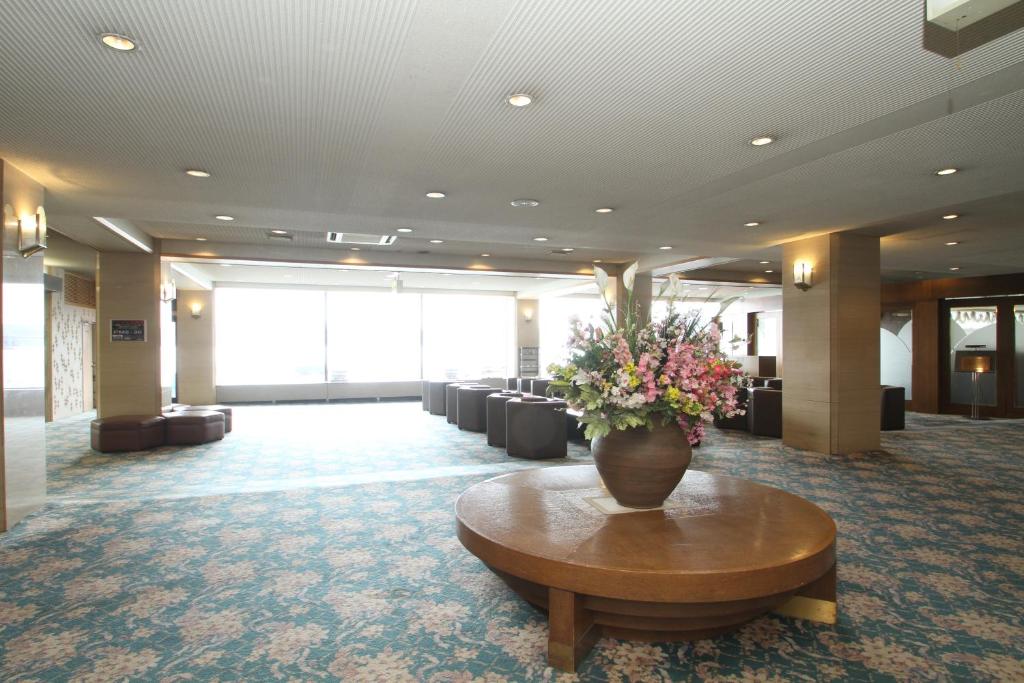- un hall avec un vase de fleurs sur une table dans l'établissement Hotel Gozensui, à Akankohan
