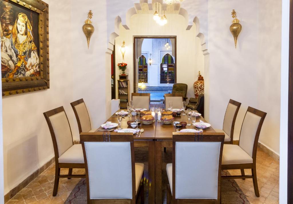 une salle à manger avec une table et des chaises en bois dans l'établissement Riad Tamarrakecht, à Marrakech