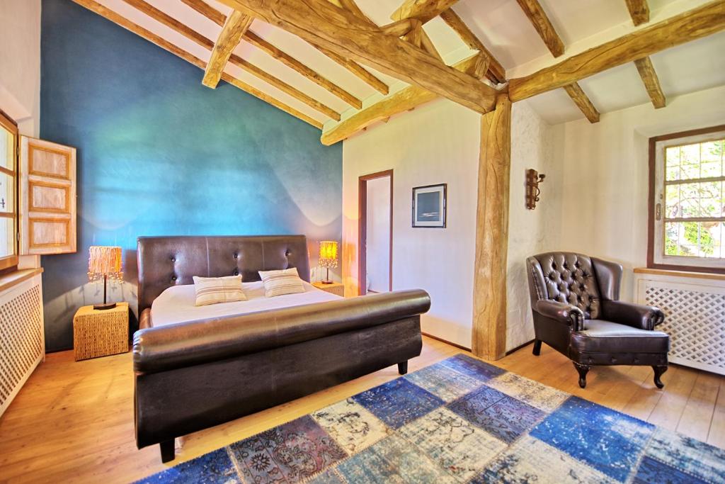 - une chambre avec un lit et un fauteuil en cuir dans l'établissement Villa Oliveta by PosarelliVillas, à Santa Lucia 29 autres photos