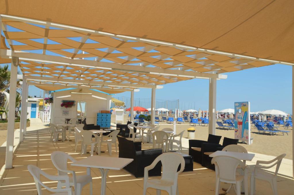 d'une terrasse avec des tables et des chaises sur la plage. dans l'établissement Hotel Karin, à Rimini