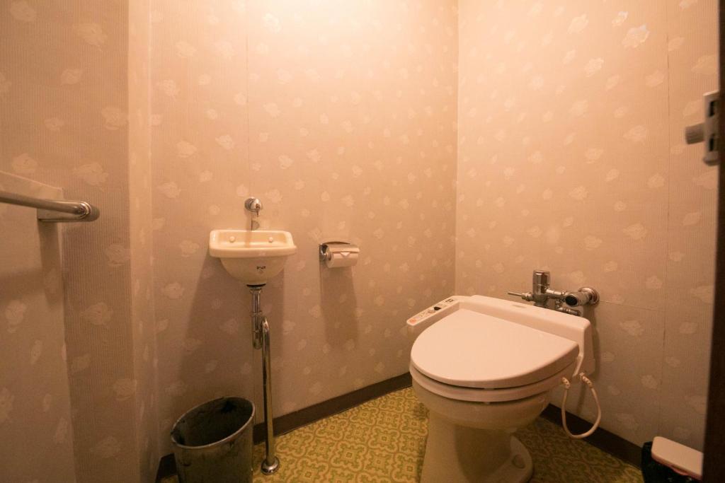 une salle de bain avec toilettes et lavabo dans l'établissement Ryokan Seishounagon, à Tsu