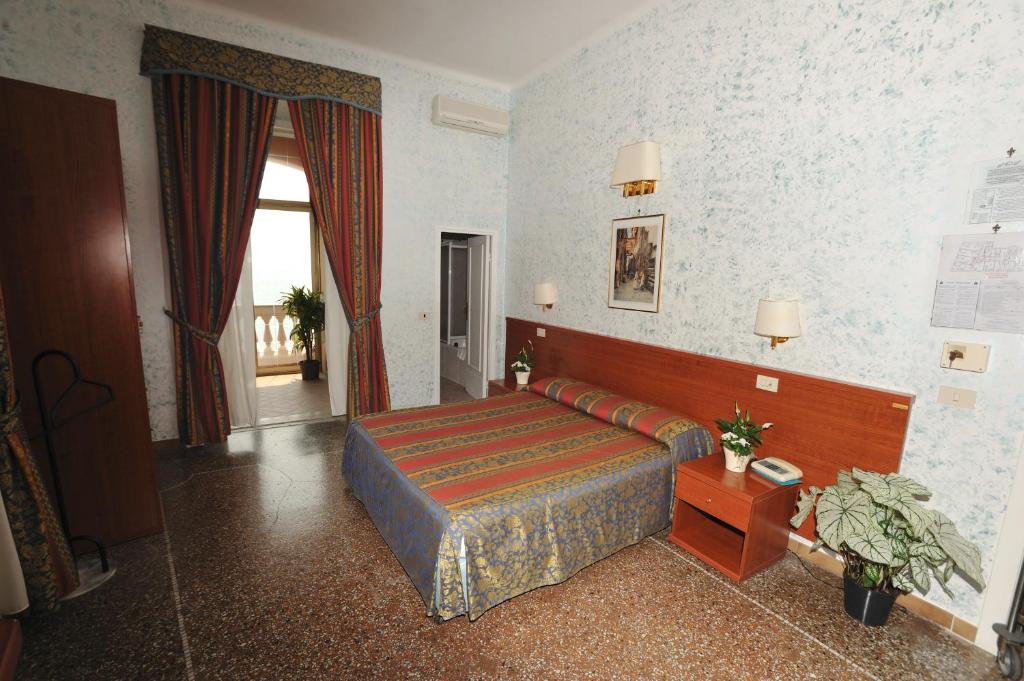 une chambre d'hôtel avec un lit et une fenêtre dans l'établissement Hotel Miramare, à Ladispoli