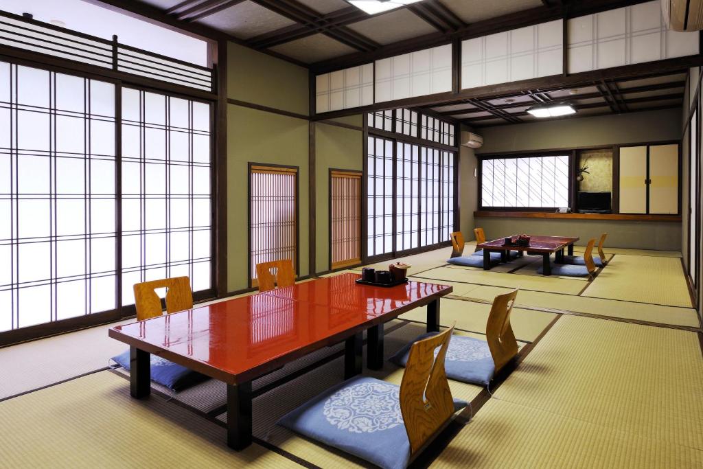 une salle à manger avec une table, des chaises et des fenêtres dans l'établissement Ryokan Seishounagon, à Tsu 36 autres photos