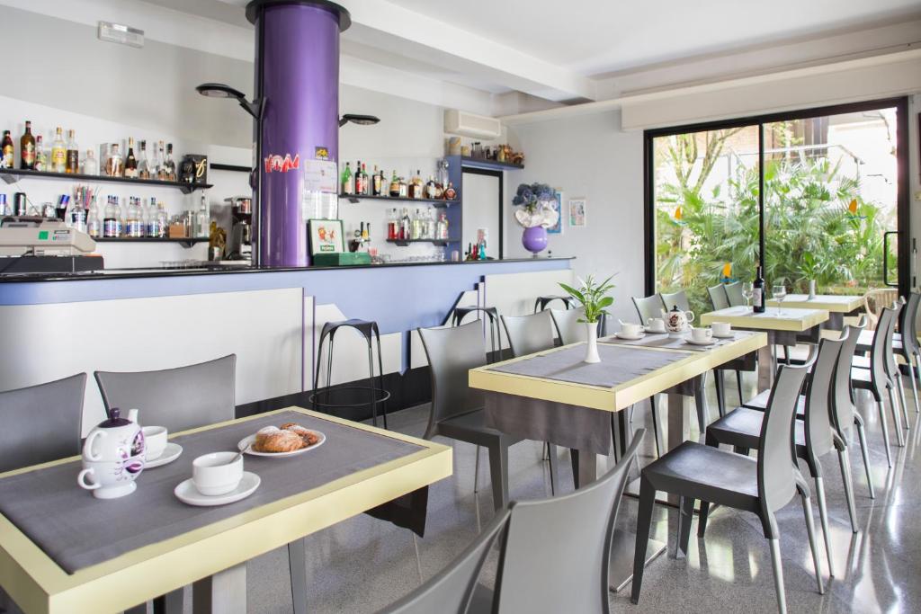un restaurant avec des tables et des chaises et un bar dans l'établissement Hotel Sampaoli, à Bellaria-Igea Marina