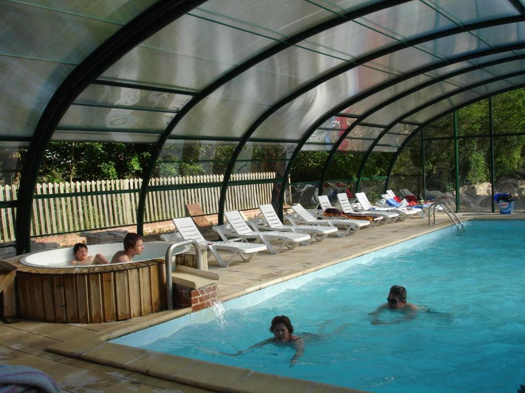un groupe de personnes dans une piscine dans l'établissement Camping Le Val de Trie, à Béhen