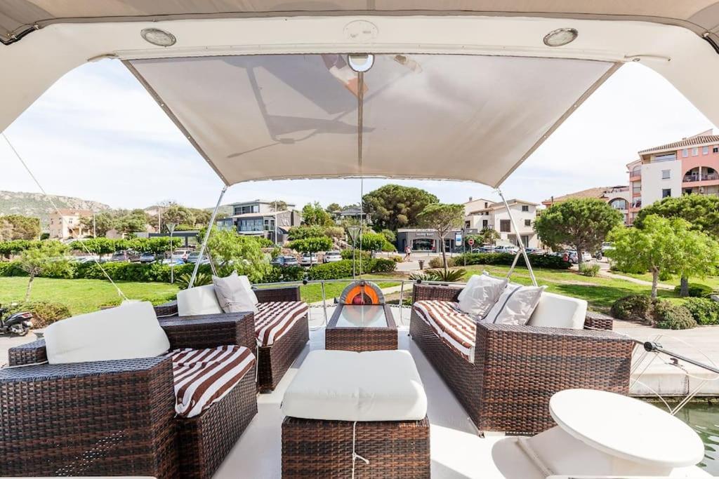 d'une terrasse avec un mobilier en osier et un parasol. dans l'établissement Ocean Yacht Trawler - Le Caloa, à Porto-Vecchio