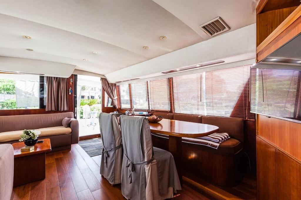 une salle de train avec une table, des chaises et un canapé dans l'établissement Ocean Yacht Trawler - Le Caloa, à Porto-Vecchio