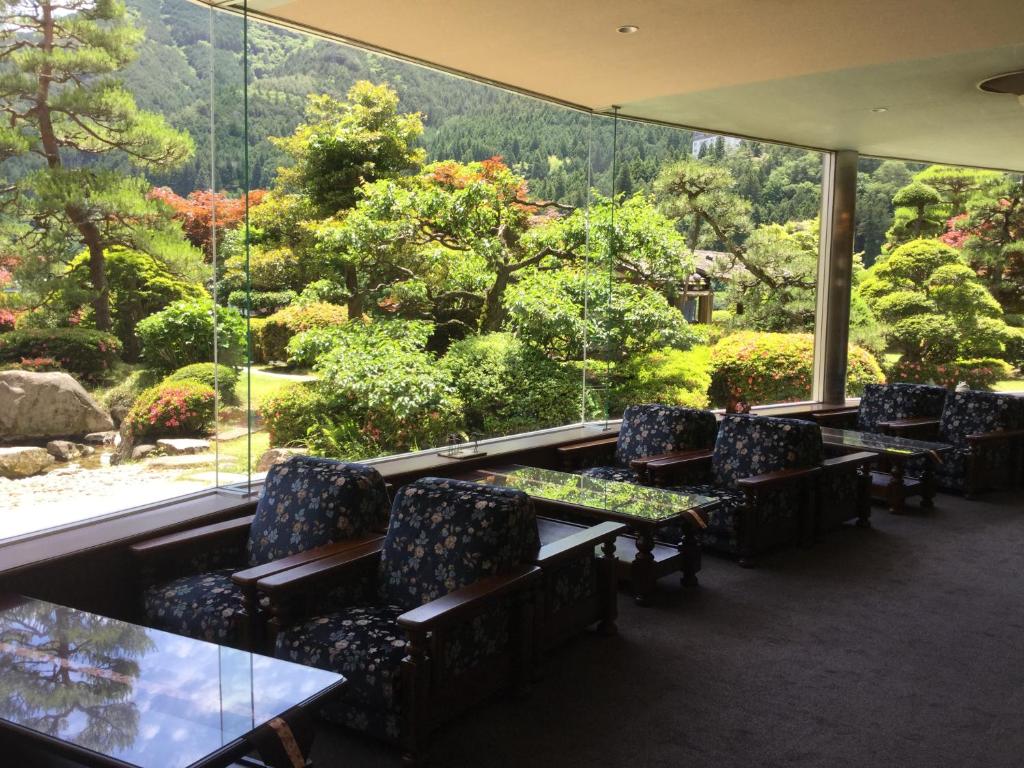 d'un restaurant avec des tables et des chaises et une vue sur le jardin. dans l'établissement Bosenkan, à Gero