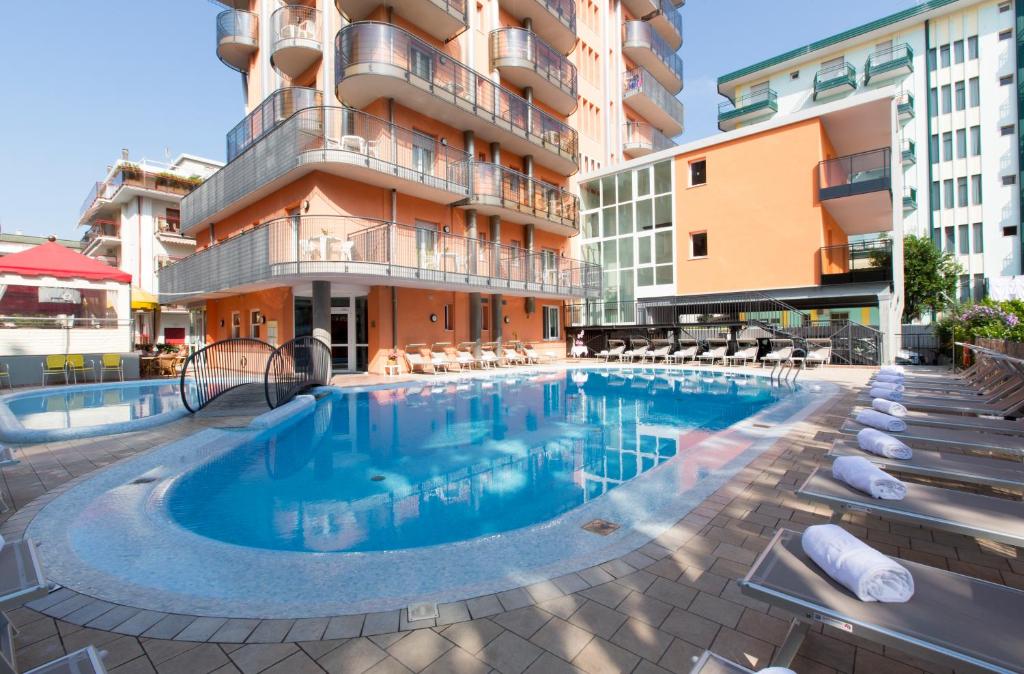 une grande piscine devant un immeuble dans l'établissement Hotel Sheila, à Lido di Jesolo