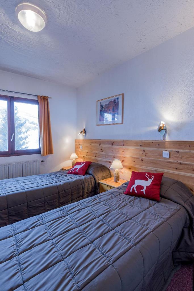 une chambre d'hôtel avec deux lits et un canapé dans l'établissement Hotel Franz, à Allos
