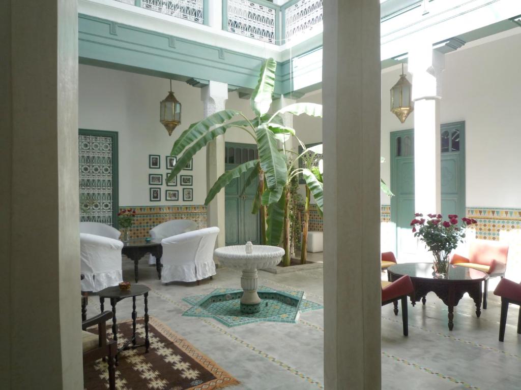 - un hall avec un mobilier blanc et une plante dans l'établissement Riad Azahar, à Marrakech
