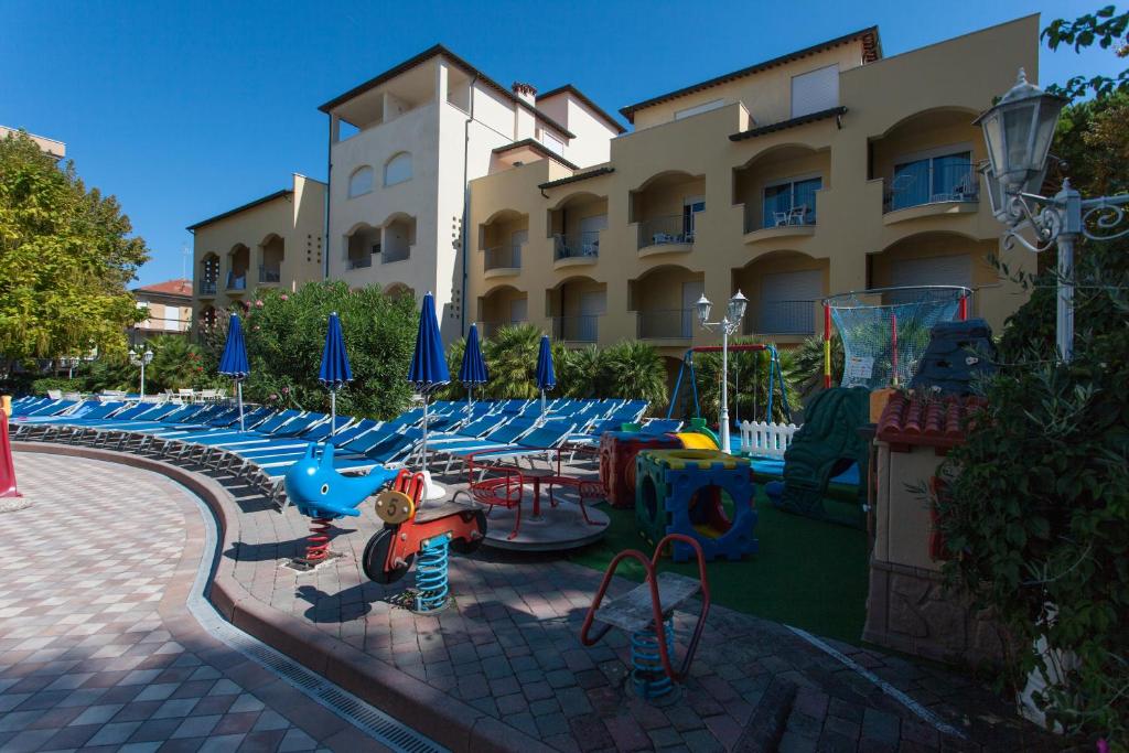 un bâtiment avec beaucoup de chaises et de parasols dans l'établissement Hotel Sport & Residenza, à Cesenatico