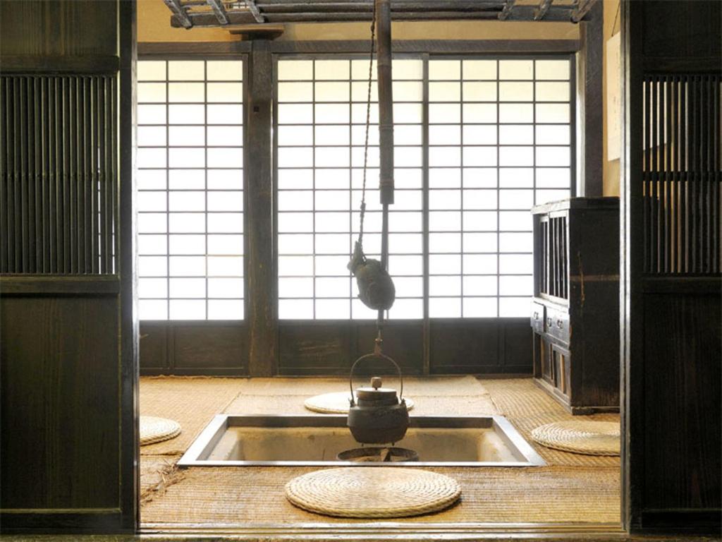 une cuisine avec une cuisinière et un chat dans la fenêtre dans l'établissement Nagataki, à Nakatsugawa