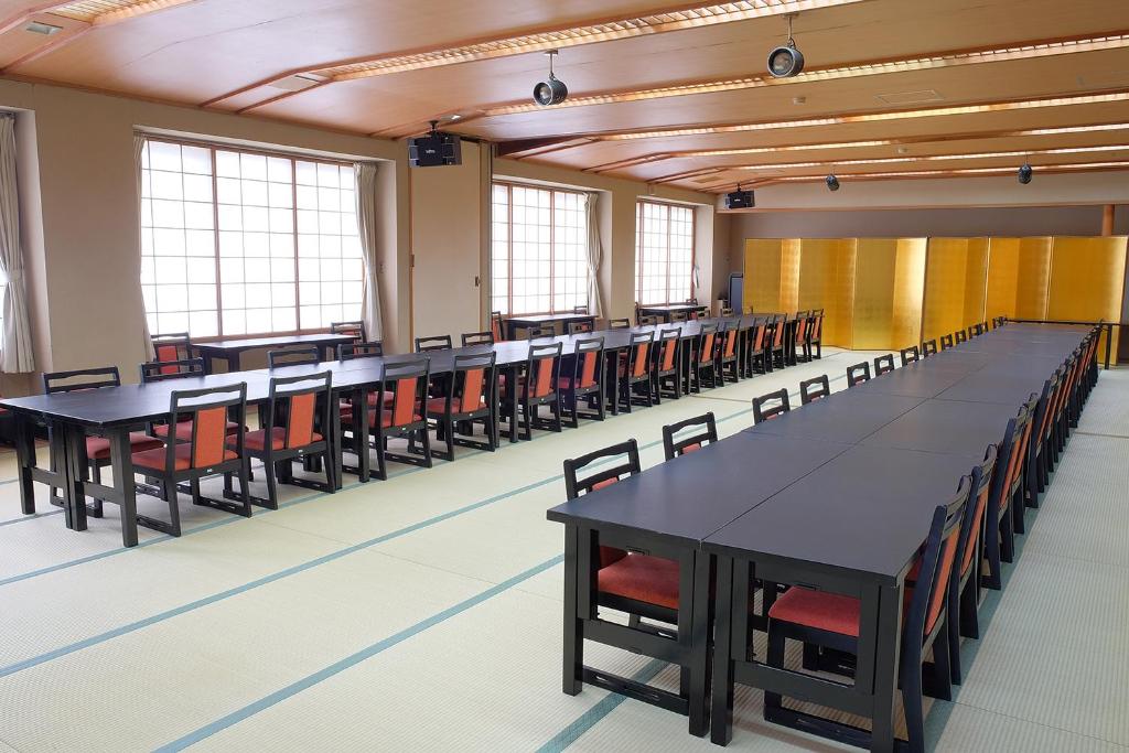 une salle de conférences vide avec des tables et des chaises dans l'établissement Sunrise Katsuura, à Nachikatsuura