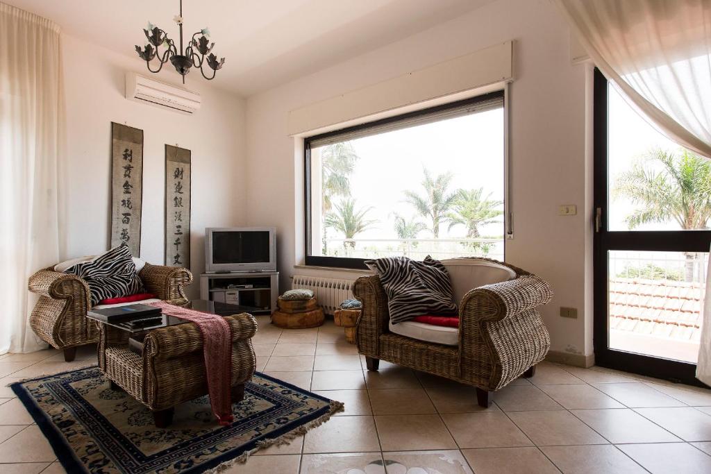 - un salon avec deux chaises et une fenêtre dans l'établissement Villa Virginia, à Pellaro