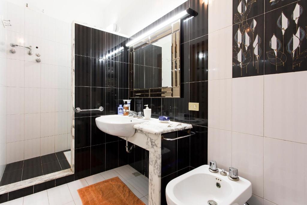 - une salle de bains en noir et blanc avec lavabo et toilettes dans l'établissement Villa Virginia, à Pellaro