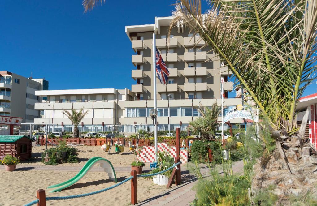 un complexe avec une aire de jeux en face d'un bâtiment dans l'établissement Hotel Ascot & Spa, à Rimini