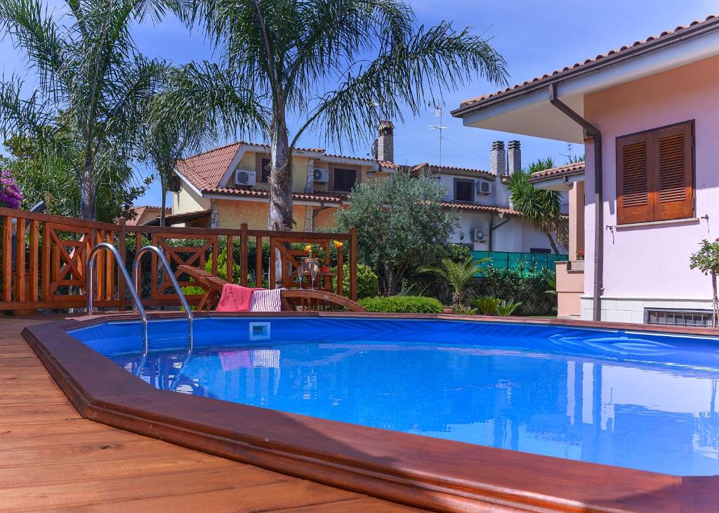 une piscine dans une cour avec une maison dans l'établissement Villa nevada -20 min da Roma, à Ladispoli