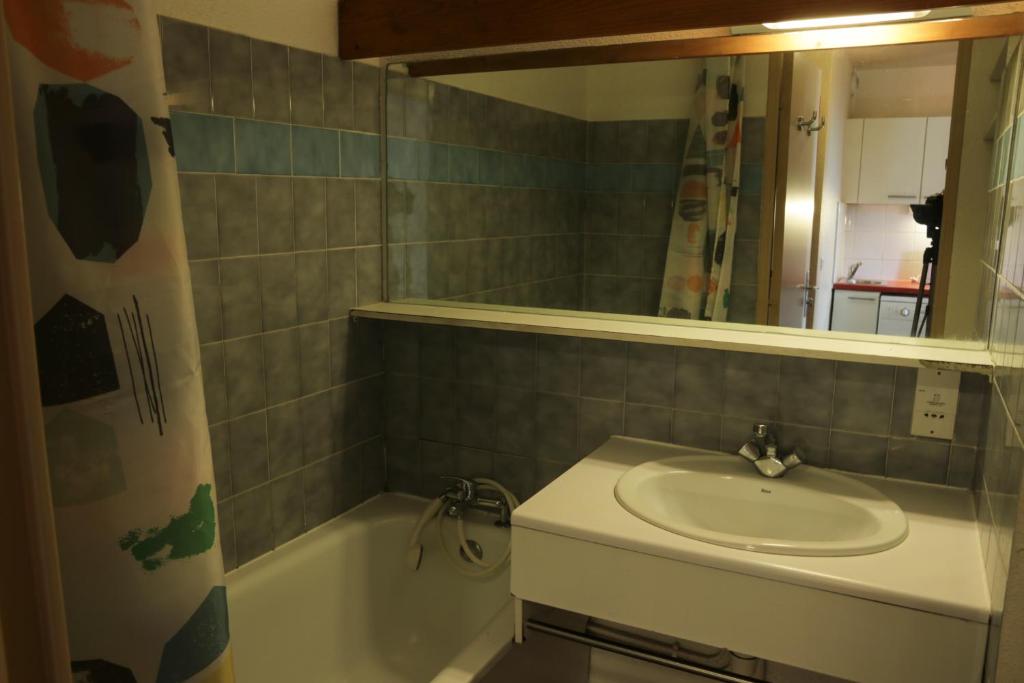 une salle de bain avec un lavabo, une baignoire et un miroir dans l'établissement SUNWEB Résidence Les Bergers, à L'Alpe-d'Huez