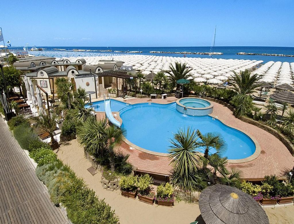 une vue aérienne d'une grande piscine à côté d'une plage dans l'établissement Hotel Solmar, à Cattolica