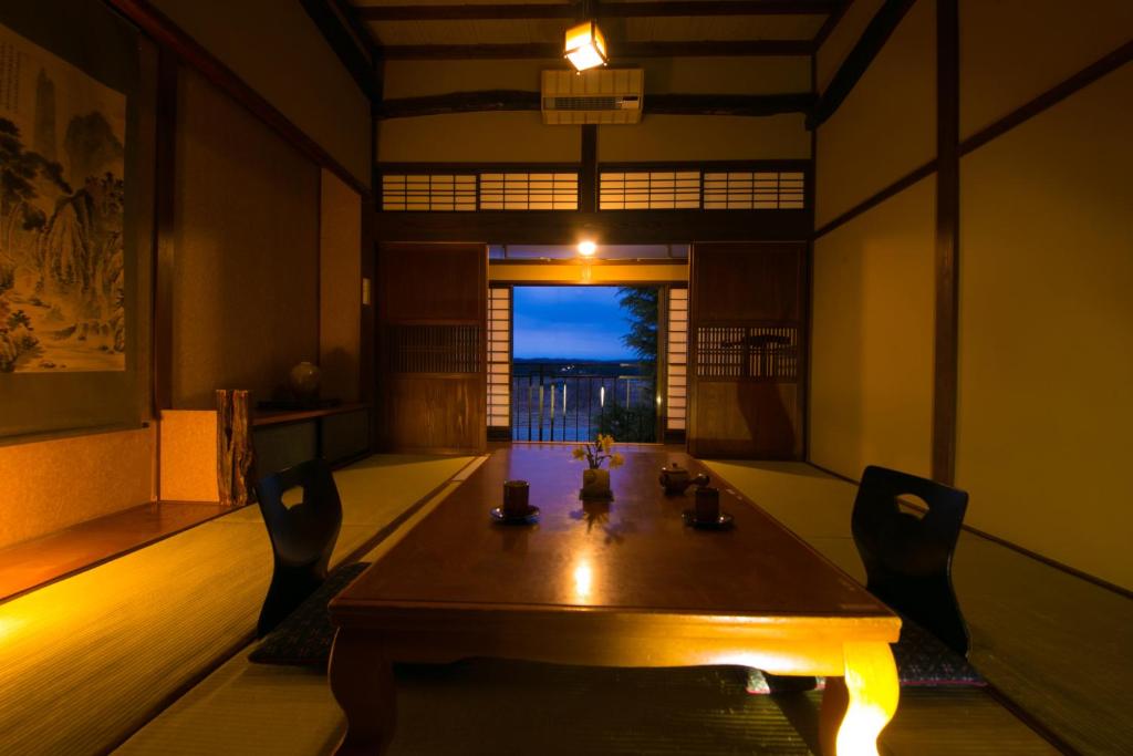 une salle à manger avec une table et des chaises en bois dans l'établissement Isamikan, à Nakagawa