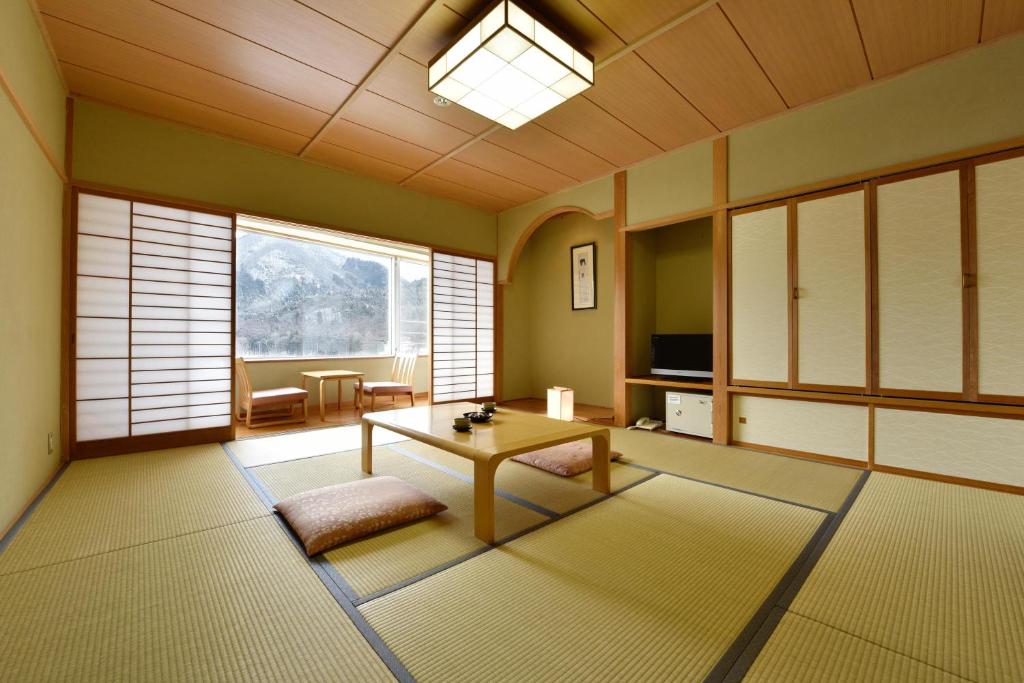 un salon avec une table et une grande fenêtre dans l'établissement Harunako Onsen Yusuge, à Takasaki