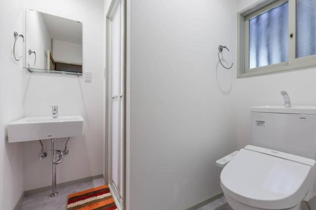une salle de bain blanche avec toilettes et lavabo dans l'établissement Kinkaku, à Kyoto