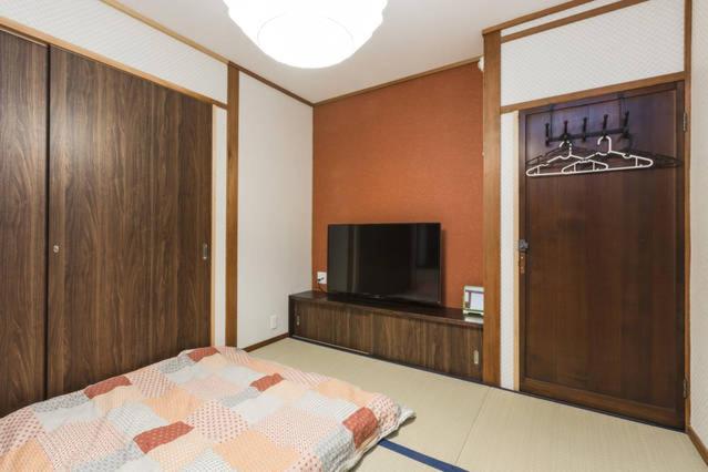 une chambre avec un lit et une télévision à écran plat dans l'établissement Kinkaku, à Kyoto