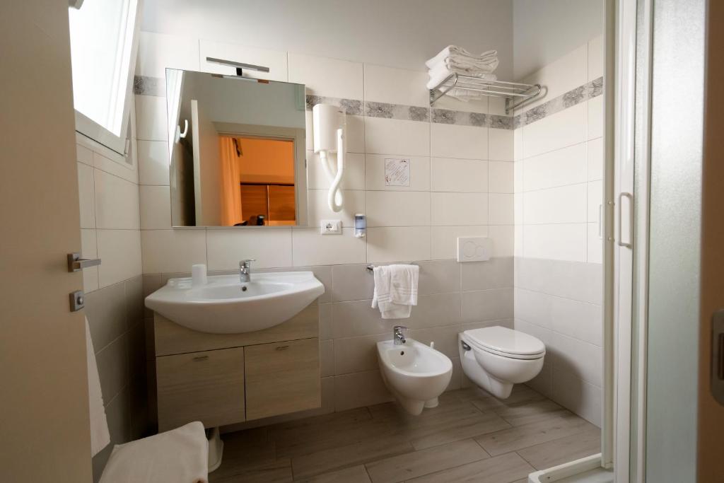 une salle de bain blanche avec un lavabo et des toilettes dans l'établissement Mondial, à Cervia