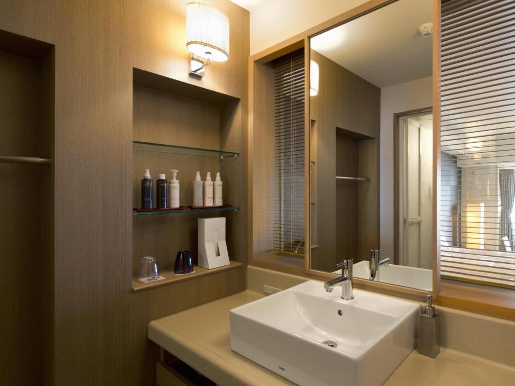 une salle de bain avec un lavabo et un miroir dans l'établissement The Lake View Toya Nonokaze Resort, à Lac Tōya