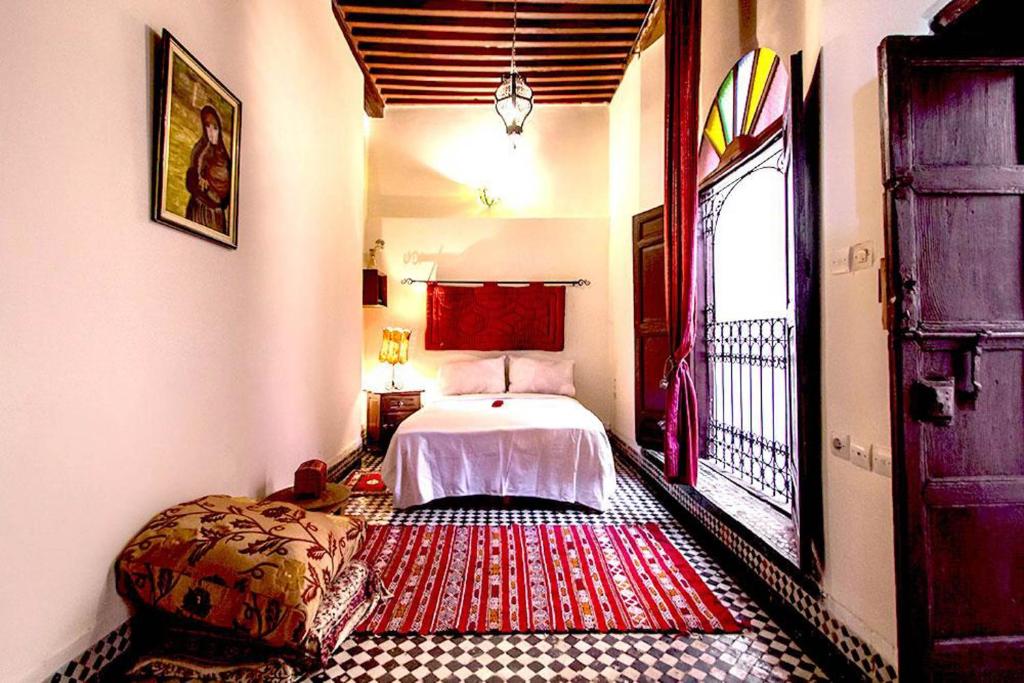 une chambre avec un lit et une grande fenêtre dans l'établissement Dar Nineta, à Fès