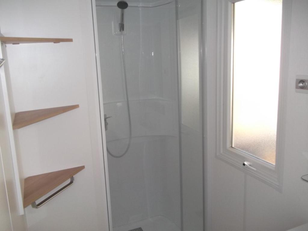 une douche avec une porte vitrée dans une salle de bain dans l'établissement Mobil Home Valras Plage, à Valras-Plage