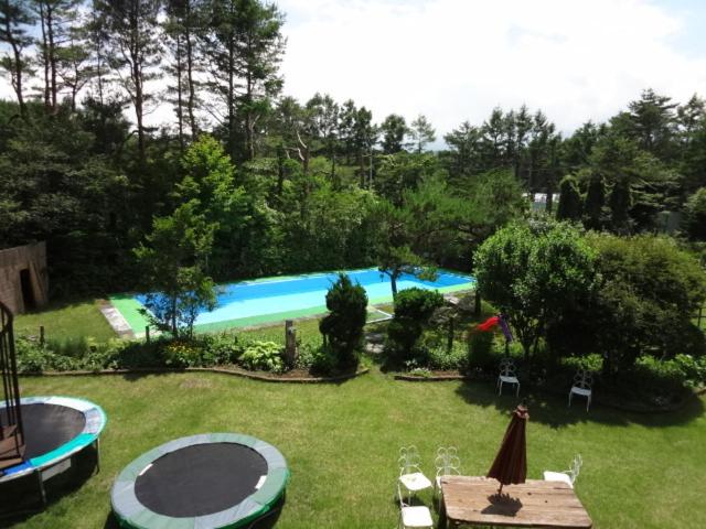 une cour avec une piscine dotée d'une table et de chaises dans l'établissement Ryokan Fujitomita, à Oshino