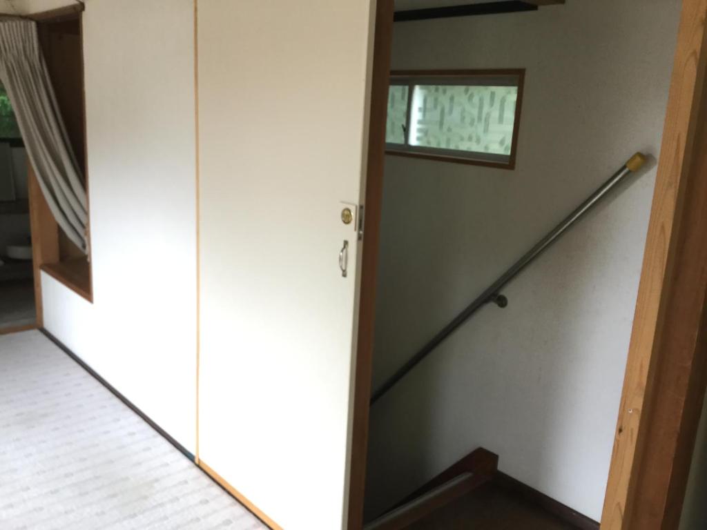 Cette chambre dispose d'un escalier, d'une fenêtre et d'une porte. dans l'établissement Bunbuku no yu, à Kasama