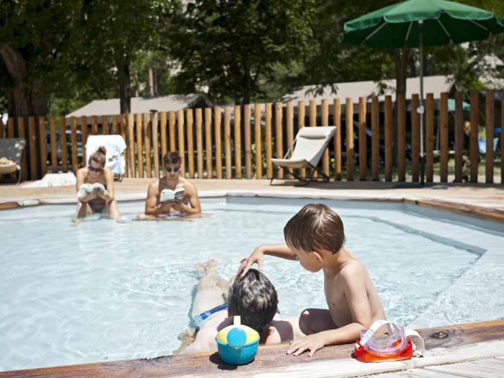 un groupe d'enfants jouant dans une piscine dans l'établissement Huttopia Gorges du Verdon, à Castellane