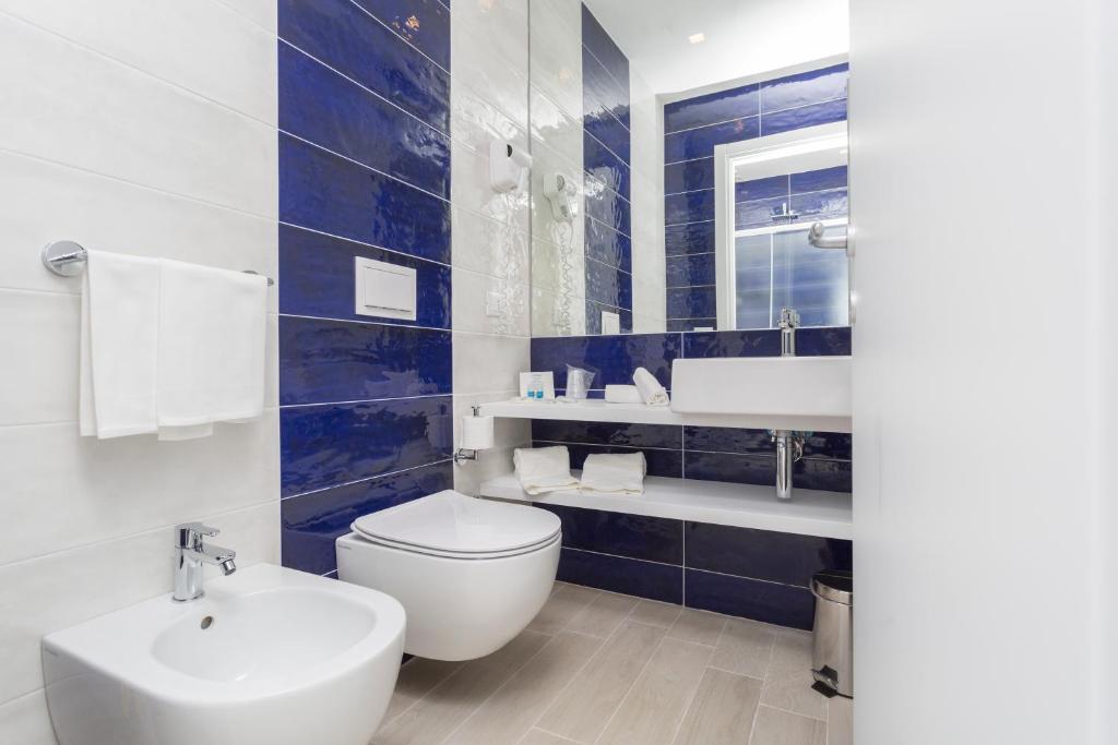 une salle de bain avec des toilettes blanches et un lavabo dans l'établissement Ticho's Greenblu Hotel, à Castellaneta Marina