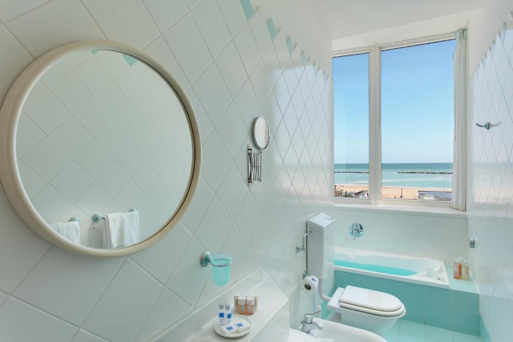 une salle de bain blanche avec un miroir et un lavabo dans l'établissement Hotel Valverde & Residenza, à Cesenatico